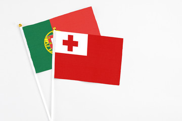 Tonga and Portugal stick flags on white background. High quality fabric, miniature national flag. Peaceful global concept.White floor for copy space.