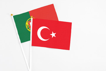 Turkey and Portugal stick flags on white background. High quality fabric, miniature national flag. Peaceful global concept.White floor for copy space.