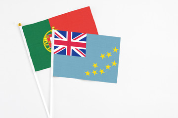 Fototapeta premium Tuvalu and Portugal stick flags on white background. High quality fabric, miniature national flag. Peaceful global concept.White floor for copy space.