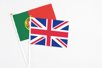 United Kingdom and Portugal stick flags on white background. High quality fabric, miniature national flag. Peaceful global concept.White floor for copy space.