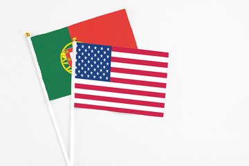 United States and Portugal stick flags on white background. High quality fabric, miniature national flag. Peaceful global concept.White floor for copy space.