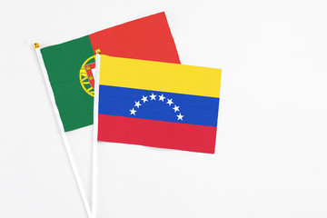 Venezuela and Portugal stick flags on white background. High quality fabric, miniature national flag. Peaceful global concept.White floor for copy space.