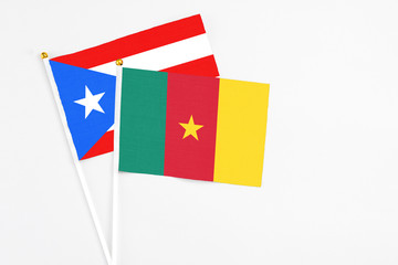Cameroon and Puerto Rico stick flags on white background. High quality fabric, miniature national flag. Peaceful global concept.White floor for copy space.