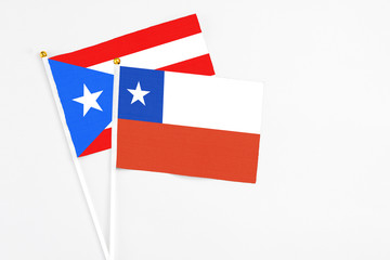 Fototapeta premium Chile and Puerto Rico stick flags on white background. High quality fabric, miniature national flag. Peaceful global concept.White floor for copy space.