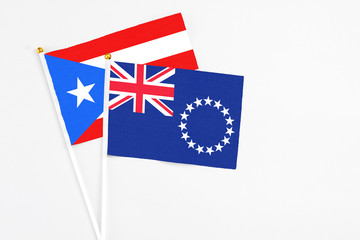 Fototapeta premium Cook Islands and Puerto Rico stick flags on white background. High quality fabric, miniature national flag. Peaceful global concept.White floor for copy space.
