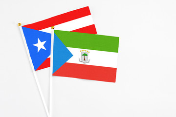 Equatorial Guinea and Puerto Rico stick flags on white background. High quality fabric, miniature national flag. Peaceful global concept.White floor for copy space.