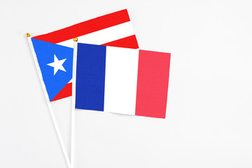 Fototapeta na wymiar France and Puerto Rico stick flags on white background. High quality fabric, miniature national flag. Peaceful global concept.White floor for copy space.