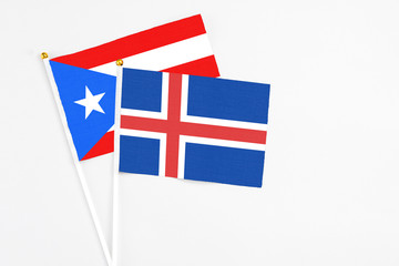 Iceland and Puerto Rico stick flags on white background. High quality fabric, miniature national flag. Peaceful global concept.White floor for copy space.