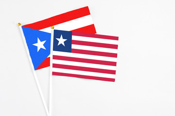 Liberia and Puerto Rico stick flags on white background. High quality fabric, miniature national flag. Peaceful global concept.White floor for copy space.