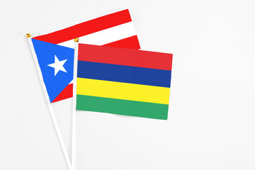 Mauritius and Puerto Rico stick flags on white background. High quality fabric, miniature national flag. Peaceful global concept.White floor for copy space.