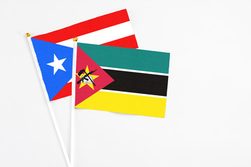 Mozambique and Puerto Rico stick flags on white background. High quality fabric, miniature national...