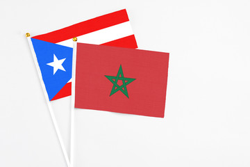 Morocco and Puerto Rico stick flags on white background. High quality fabric, miniature national flag. Peaceful global concept.White floor for copy space.