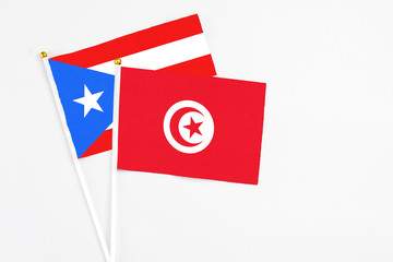 Tunisia and Puerto Rico stick flags on white background. High quality fabric, miniature national flag. Peaceful global concept.White floor for copy space.
