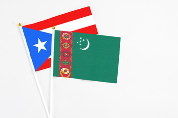 Turkmenistan and Puerto Rico stick flags on white background. High quality fabric, miniature national flag. Peaceful global concept.White floor for copy space.