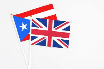 Fototapeta premium United Kingdom and Puerto Rico stick flags on white background. High quality fabric, miniature national flag. Peaceful global concept.White floor for copy space.