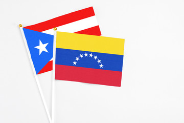 Venezuela and Puerto Rico stick flags on white background. High quality fabric, miniature national flag. Peaceful global concept.White floor for copy space.