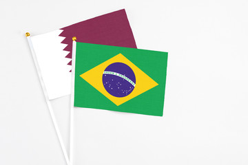 Brazil and Qatar stick flags on white background. High quality fabric, miniature national flag. Peaceful global concept.White floor for copy space.
