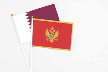 Montenegro and Qatar stick flags on white background. High quality fabric, miniature national flag. Peaceful global concept.White floor for copy space.