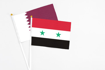 Syria and Qatar stick flags on white background. High quality fabric, miniature national flag. Peaceful global concept.White floor for copy space.