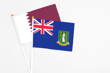 British Virgin Islands and Qatar stick flags on white background. High quality fabric, miniature national flag. Peaceful global concept.White floor for copy space.