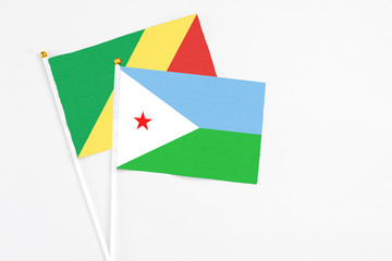 Djibouti and Republic Of The Congo stick flags on white background. High quality fabric, miniature national flag. Peaceful global concept.White floor for copy space.