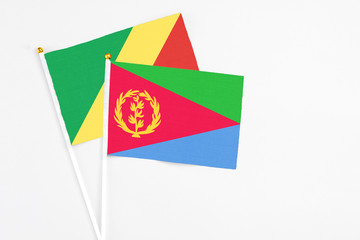 Eritrea and Republic Of The Congo stick flags on white background. High quality fabric, miniature national flag. Peaceful global concept.White floor for copy space.