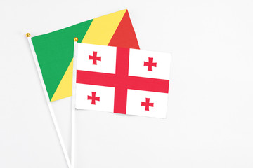 Georgia and Republic Of The Congo stick flags on white background. High quality fabric, miniature national flag. Peaceful global concept.White floor for copy space.