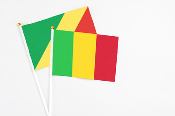 Mali and Republic Of The Congo stick flags on white background. High quality fabric, miniature national flag. Peaceful global concept.White floor for copy space.