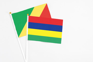 Mauritius and Republic Of The Congo stick flags on white background. High quality fabric, miniature national flag. Peaceful global concept.White floor for copy space.