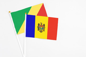 Moldova and Republic Of The Congo stick flags on white background. High quality fabric, miniature national flag. Peaceful global concept.White floor for copy space.