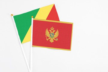 Montenegro and Republic Of The Congo stick flags on white background. High quality fabric, miniature national flag. Peaceful global concept.White floor for copy space.