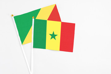 Senegal and Republic Of The Congo stick flags on white background. High quality fabric, miniature national flag. Peaceful global concept.White floor for copy space.
