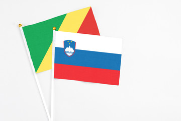 Slovenia and Republic Of The Congo stick flags on white background. High quality fabric, miniature national flag. Peaceful global concept.White floor for copy space.