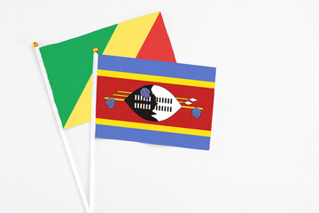 Swaziland and Republic Of The Congo stick flags on white background. High quality fabric, miniature national flag. Peaceful global concept.White floor for copy space.