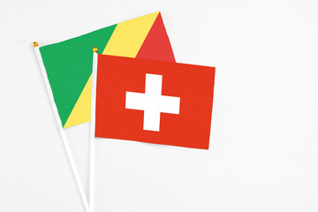 Switzerland and Republic Of The Congo stick flags on white background. High quality fabric, miniature national flag. Peaceful global concept.White floor for copy space.