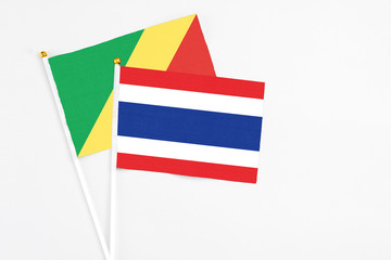 Thailand and Republic Of The Congo stick flags on white background. High quality fabric, miniature national flag. Peaceful global concept.White floor for copy space.