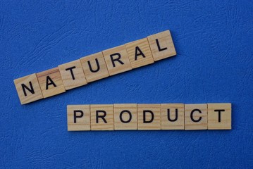 word natural product made from brown wooden letters lies on a blue table