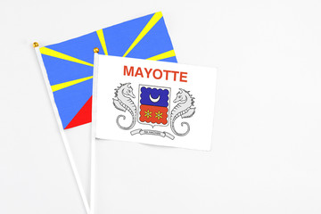 Mayotte and Reunion stick flags on white background. High quality fabric, miniature national flag. Peaceful global concept.White floor for copy space.
