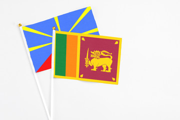 Sri Lanka and Reunion stick flags on white background. High quality fabric, miniature national flag. Peaceful global concept.White floor for copy space.