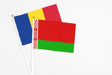 Belarus and Romania stick flags on white background. High quality fabric, miniature national flag. Peaceful global concept.White floor for copy space.