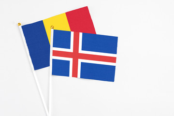 Obraz premium Iceland and Romania stick flags on white background. High quality fabric, miniature national flag. Peaceful global concept.White floor for copy space.
