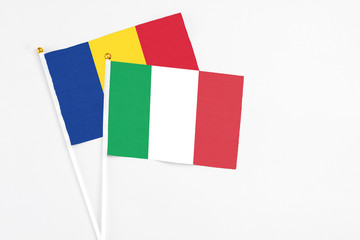 Fototapeta premium Italy and Romania stick flags on white background. High quality fabric, miniature national flag. Peaceful global concept.White floor for copy space.