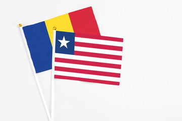 Liberia and Romania stick flags on white background. High quality fabric, miniature national flag. Peaceful global concept.White floor for copy space.
