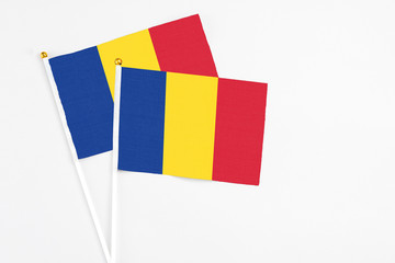 Romania and Romania stick flags on white background. High quality fabric, miniature national flag. Peaceful global concept.White floor for copy space.