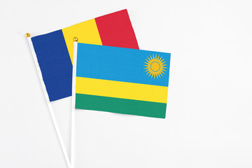 Rwanda and Romania stick flags on white background. High quality fabric, miniature national flag. Peaceful global concept.White floor for copy space.