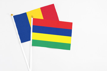 Mauritius and Romania stick flags on white background. High quality fabric, miniature national flag. Peaceful global concept.White floor for copy space.