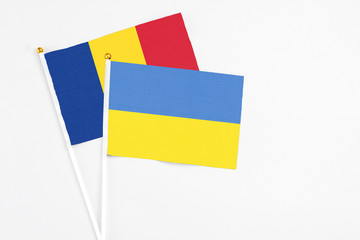 Ukraine and Romania stick flags on white background. High quality fabric, miniature national flag. Peaceful global concept.White floor for copy space.