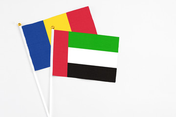 United Arab Emirates and Romania stick flags on white background. High quality fabric, miniature national flag. Peaceful global concept.White floor for copy space.