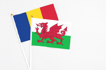 Wales and Romania stick flags on white background. High quality fabric, miniature national flag. Peaceful global concept.White floor for copy space.