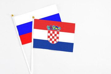 Croatia and Russia stick flags on white background. High quality fabric, miniature national flag. Peaceful global concept.White floor for copy space.